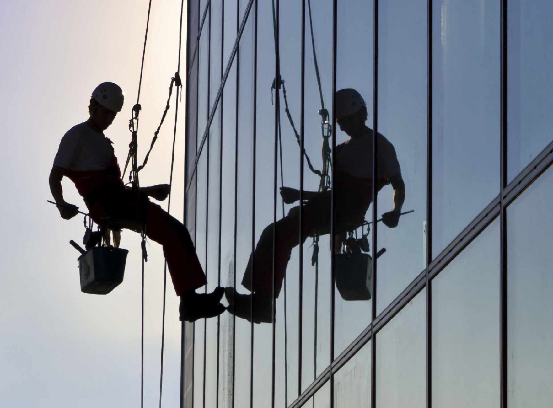 Man cleaning building's window