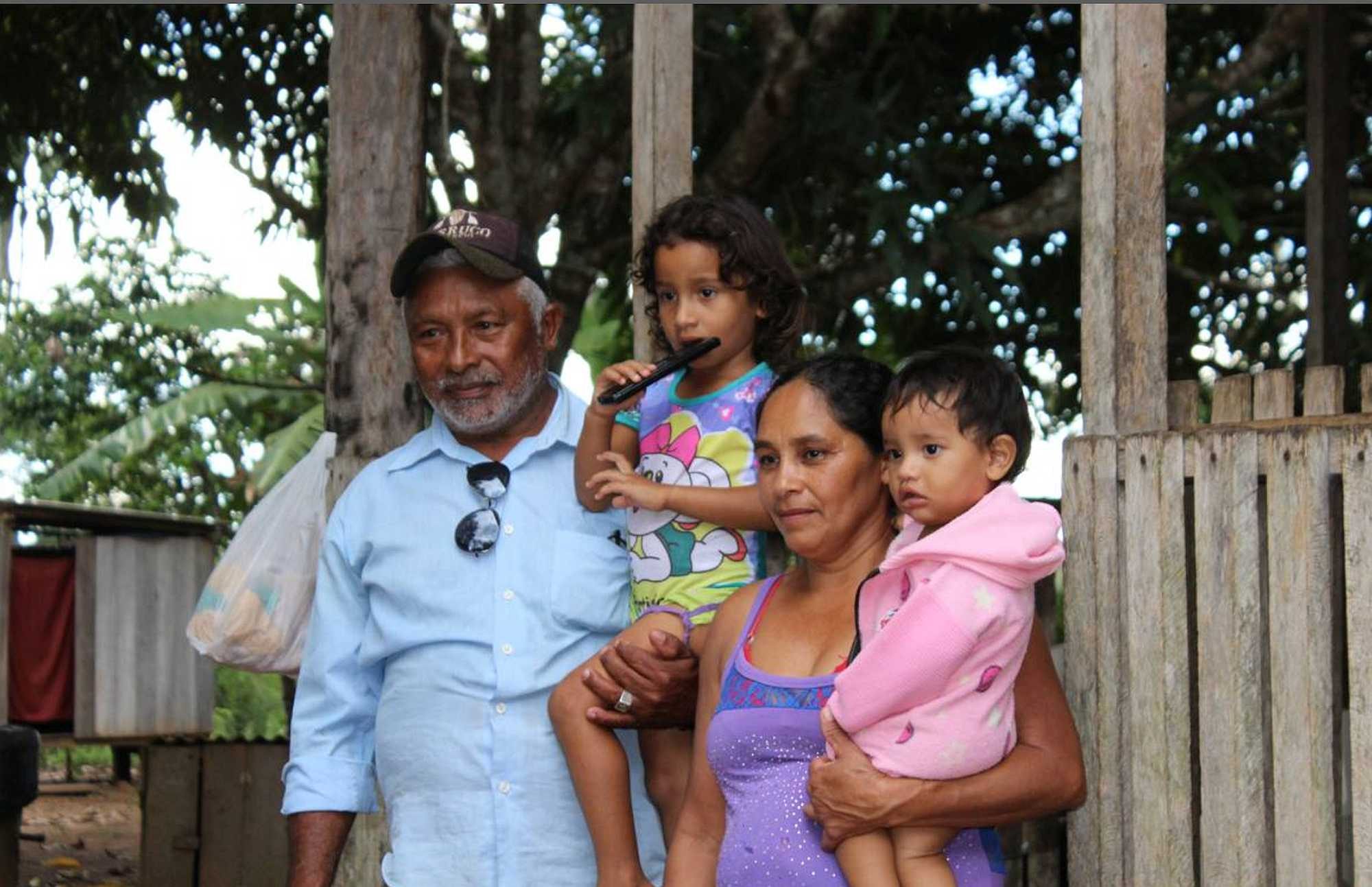 Chief Geraldo Apurina, wife and children in front of their house - Chris Arsenault/Thomson Reuters Foundation