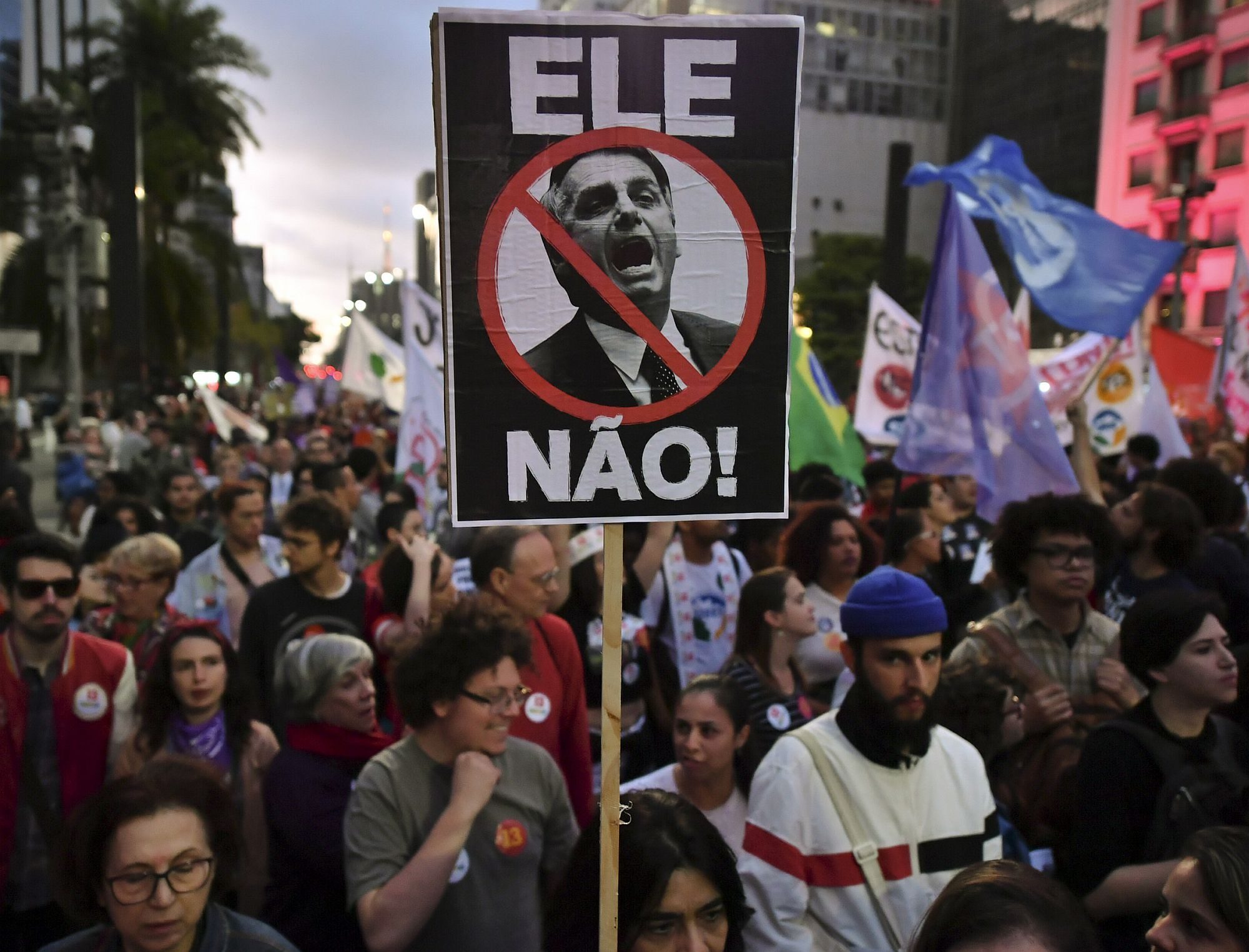 Protesters in the streets against Bolsonaro. "Not him,"says the sign