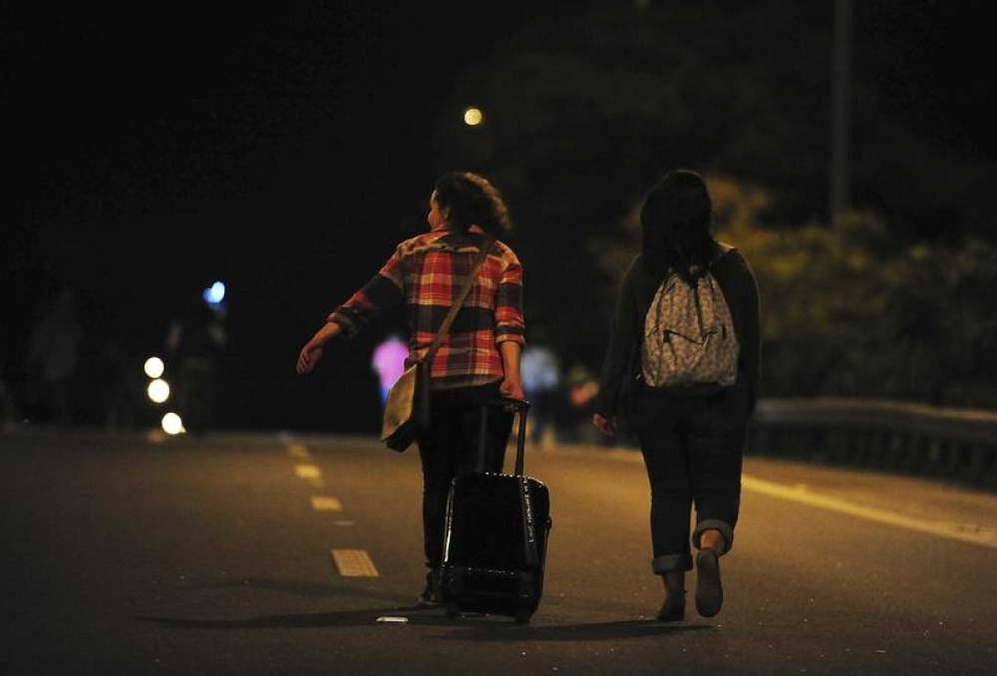 Women walk along the Dutra highway to reach Guarulhos International Airport - Photo by Thomson Reuters Foundation
