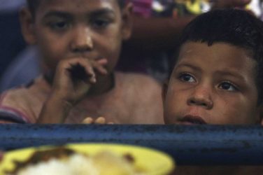 Venezuelan kids wait for a meal at a migrant shelter in Boa Vista, Roraima state, Brazil - Eraldo Peres/AP