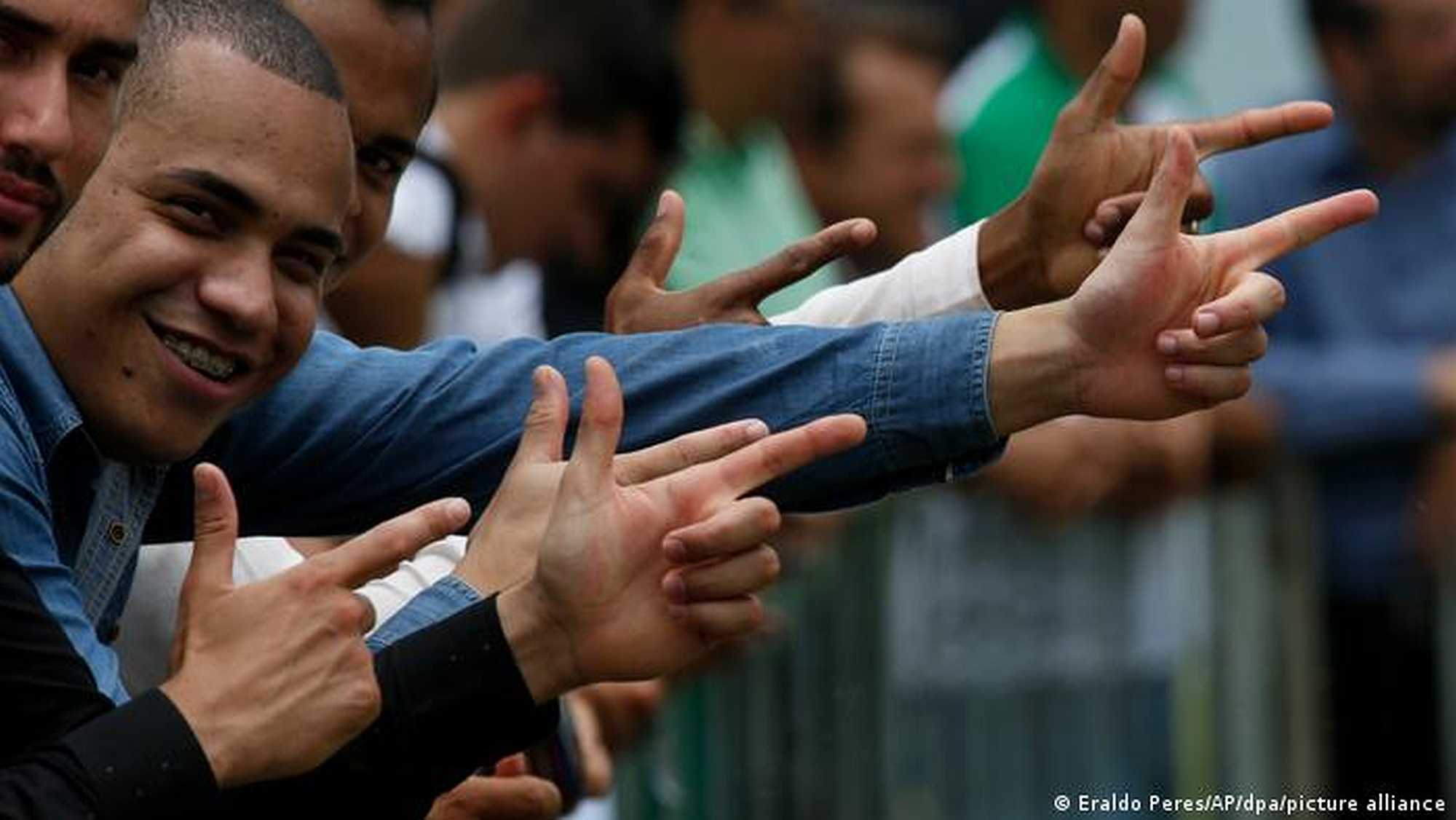 Fans of Brazilian president making pistol-like hand gestures
