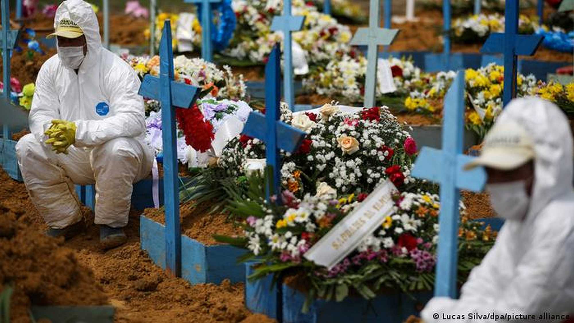 Cemetery workers are forced to don protective clothing during a funeral service in the state of Manaus