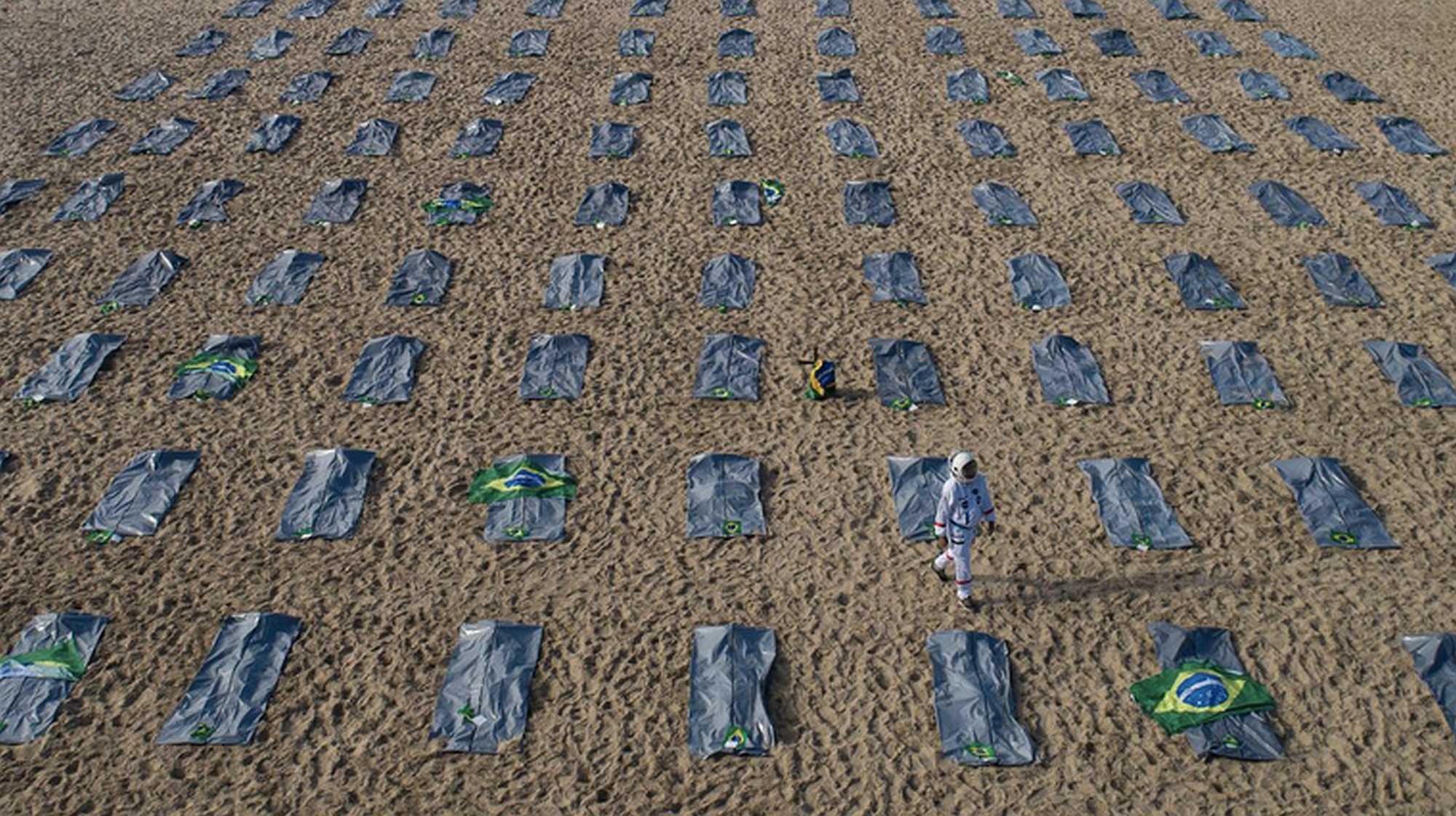 Body bags on Rio's Copacabana beach symbolize the victims of the pandemic. -Fernando Souza/dpa/Alamy