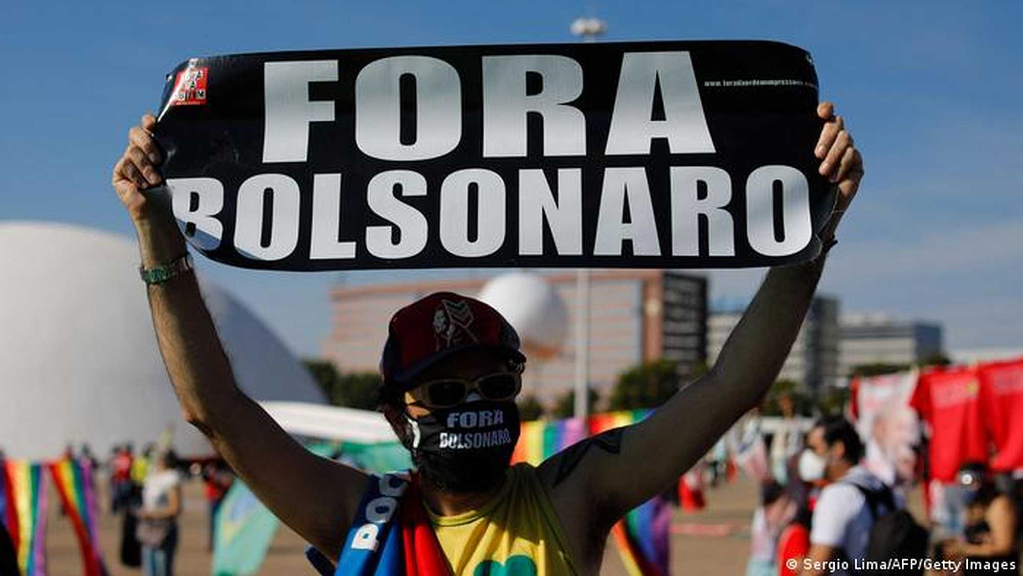 A protester holds a sign reading "Bolsonaro out" at a protest in Brasília