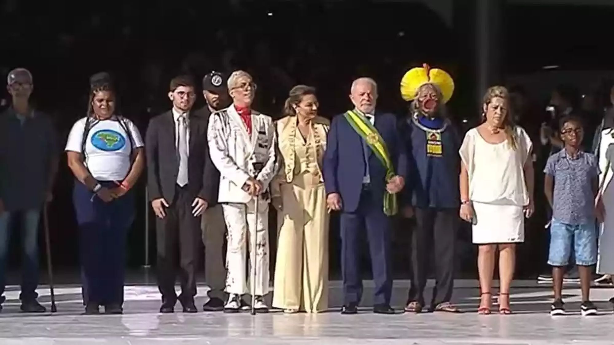 Lula walks up the Planalto palace ramp with his wife and a group that included Chief Raoni of the Kayapó tribe, a Black boy, and a trash pick up lady.