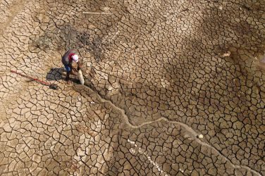 A man searches for water on Puraquequara Lake, which has been affected by historic drought in the Amazon, in Manaus Brazil - REUTERS/Bruno Kelly