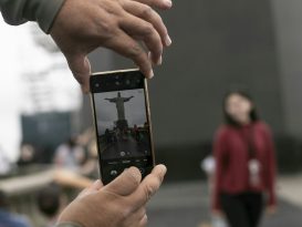 A tourist captures a moment in front of the Christ the Redeemer statue in Rio.